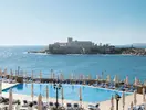 Basen z leżakami w Corinthia St. George's Bay nad morzem