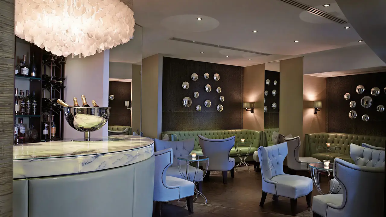 Elegancki bar z jasnymi fotelami w Corinthia St. George's Bay