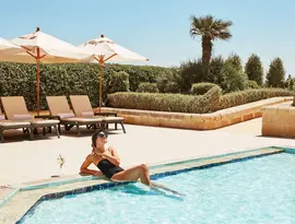 Kobieta odpoczywająca przy basenie w Corinthia St. George's Bay