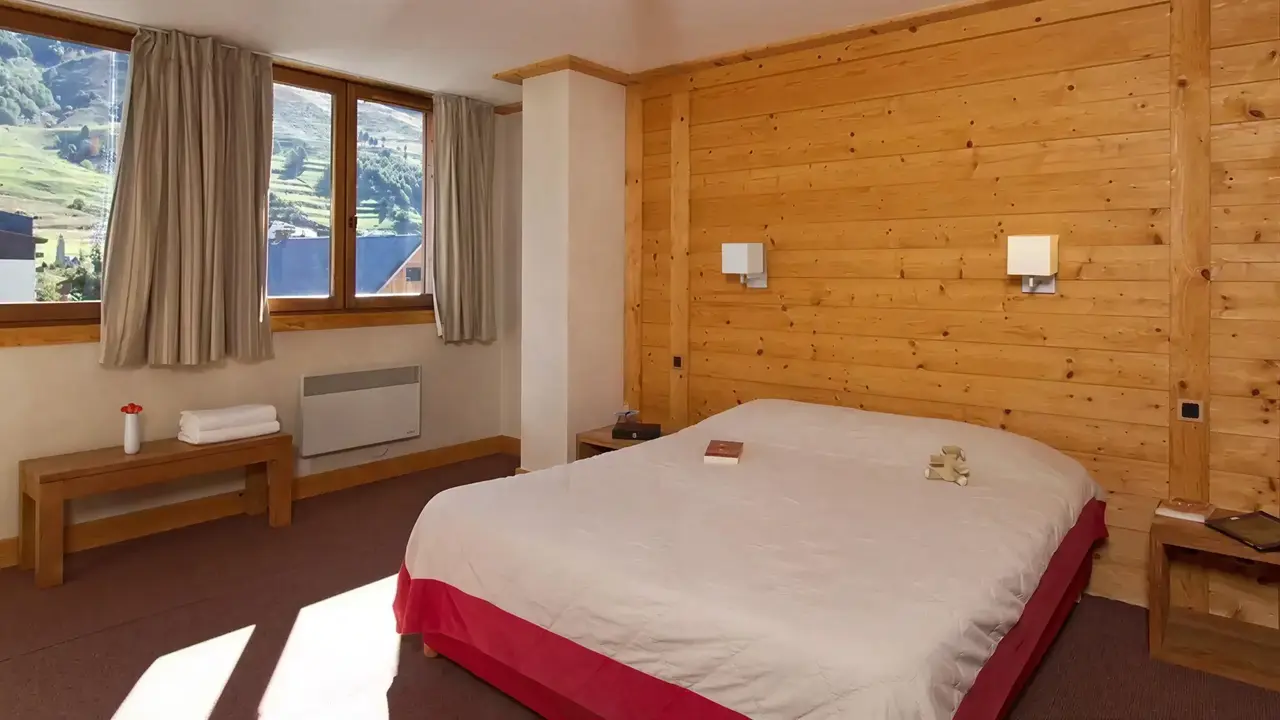 Przytulna sypialnia z drewnianą ścianą w Cortina