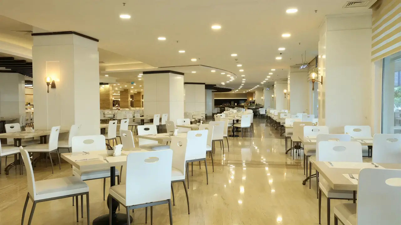 Jasna restauracja w Crystal Admiral Aqua Collection z białymi krzesłami