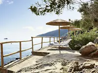 Taras z leżakami nad morzem w Daios Cove Luxury Resort & Villas