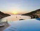 Basen typu infinity w Daios Cove Luxury Resort & Villas o zachodzie słońca