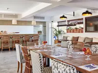 Jadalnia w hotelu Delamar z drewnianymi stołami
