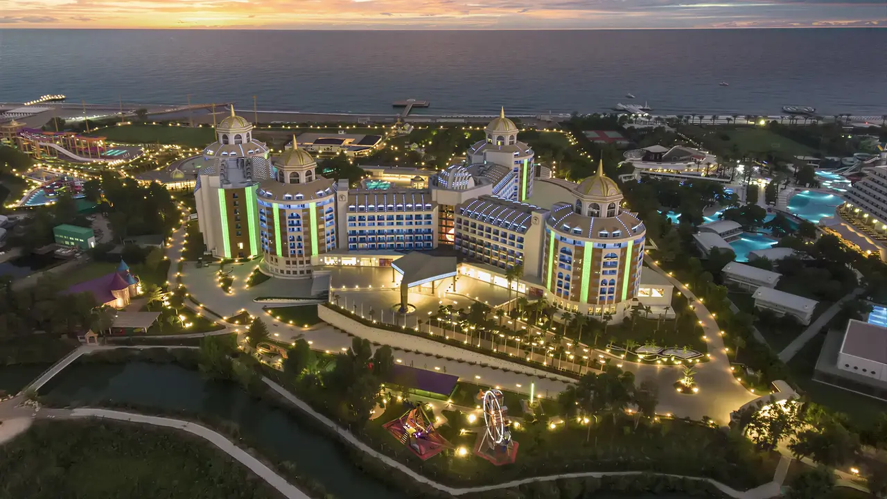 Panoramiczny widok na kompleks Delphin Be Grand Resort (ex Botanik Lara) o zmierzchu