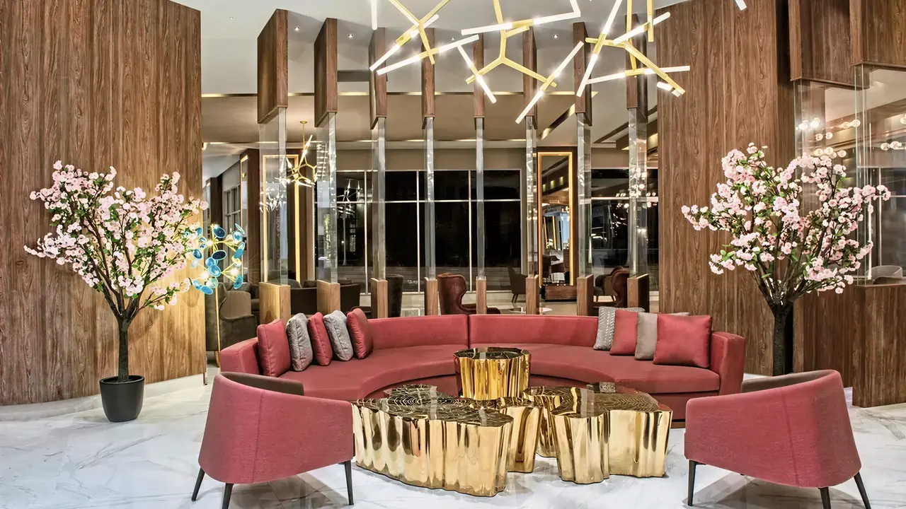 Nowoczesny salon w Delphin Be Grand Resort (ex Botanik Lara) z czerwonymi kanapami