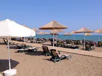 Plaża z leżakami i parasolami w Delphin Be Grand Resort (ex Botanik Lara)