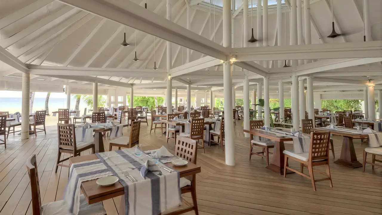 Restauracja w Diamonds Athuruga Beach & Water Villas z drewnianymi stołami