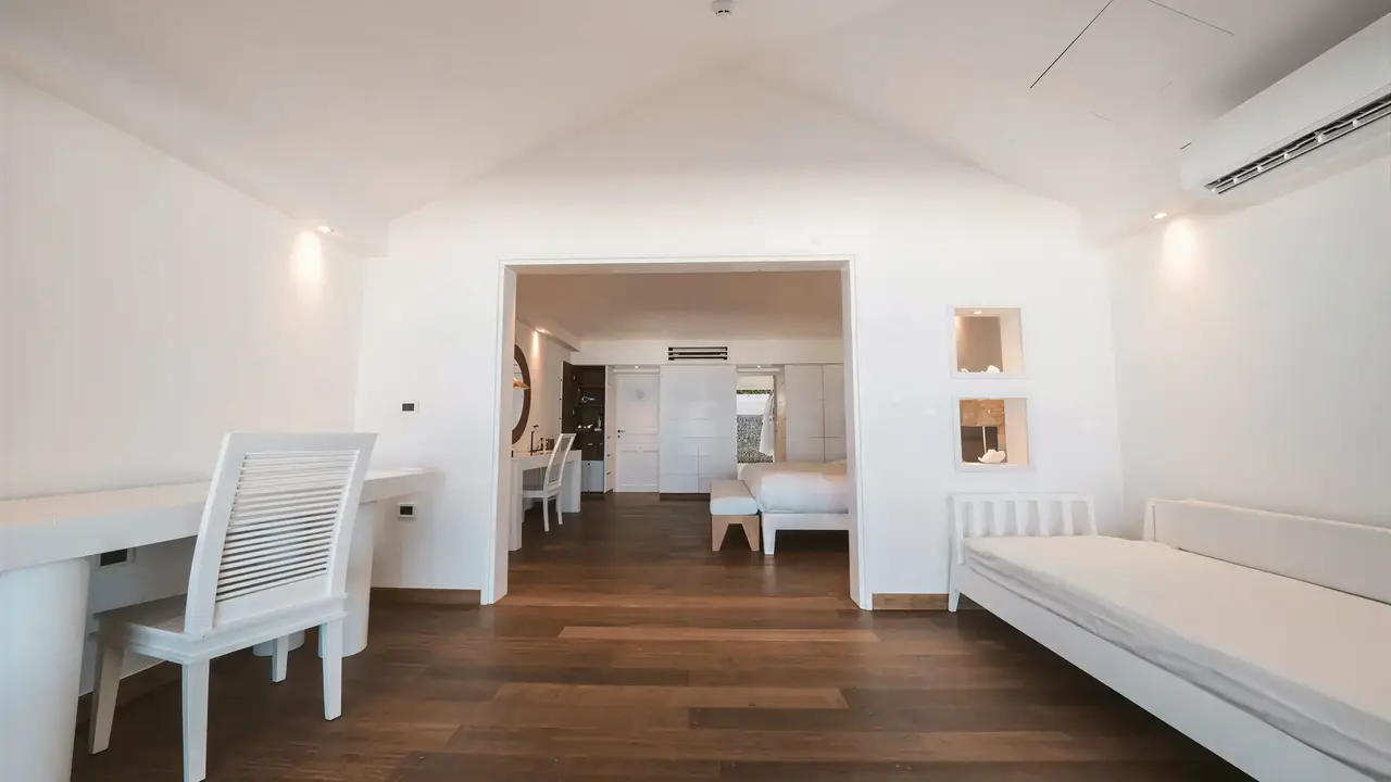 Wnętrze pokoju w Diamonds Athuruga Beach & Water Villas z białymi meblami