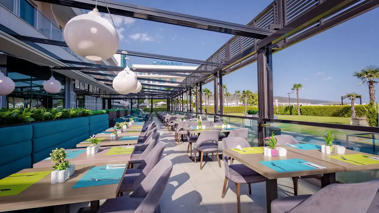 Taras restauracyjny w DIT Evrika Beach Club z nakrytymi stołami