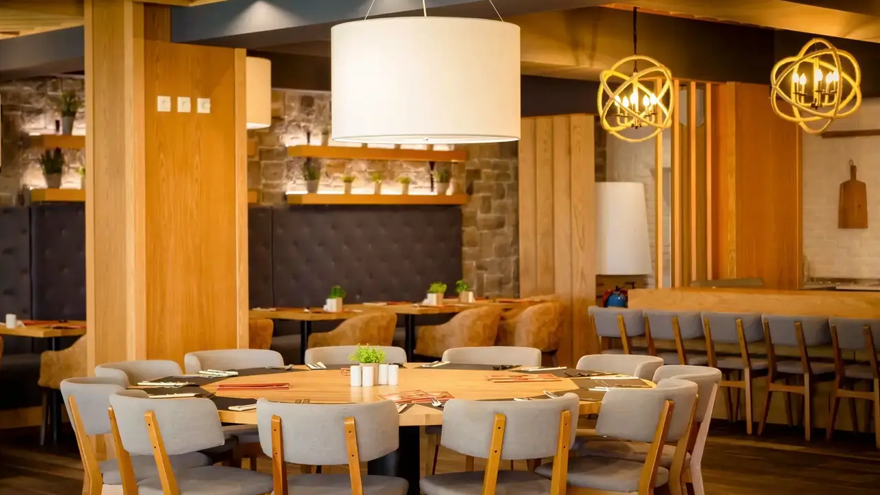 Restauracja w DIT Evrika Beach Club z drewnianymi stołami i krzesłami