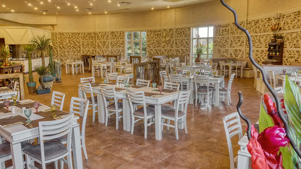 Restauracja w DIT Evrika Beach Club z białymi stołami i krzesłami