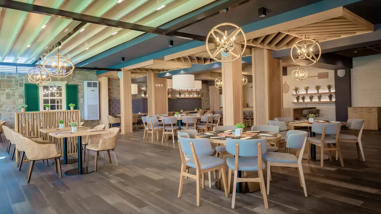 Wnętrze restauracji w DIT Evrika Beach Club z drewnianymi stołami