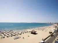 Plaża z białymi parasolami w DIT Evrika Beach Club