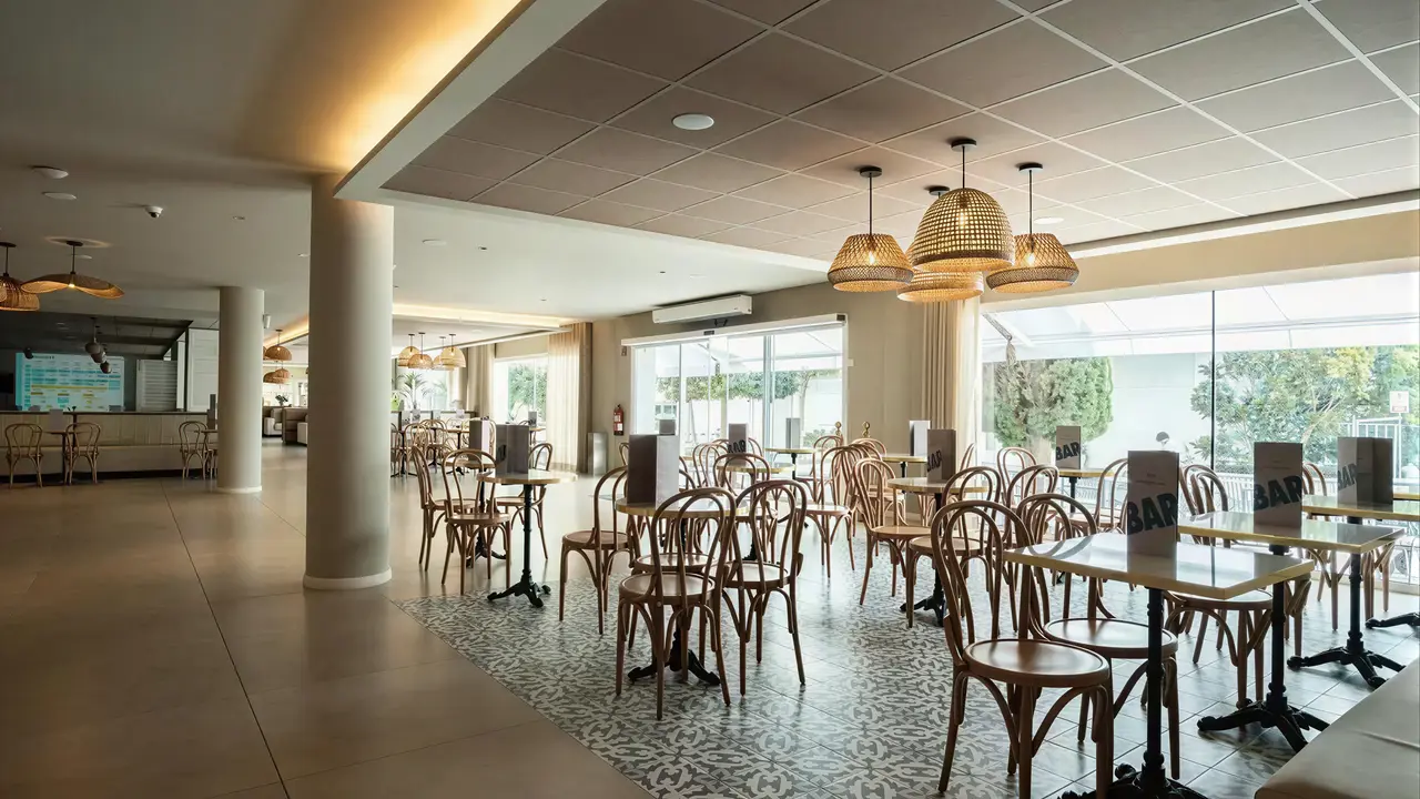 Restauracja w hotelu Don Juan Tossa z drewnianymi krzesłami