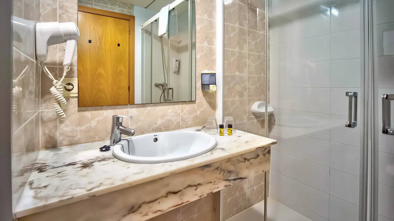 Łazienka w hotelu Don Juan Tossa z umywalką i prysznicem