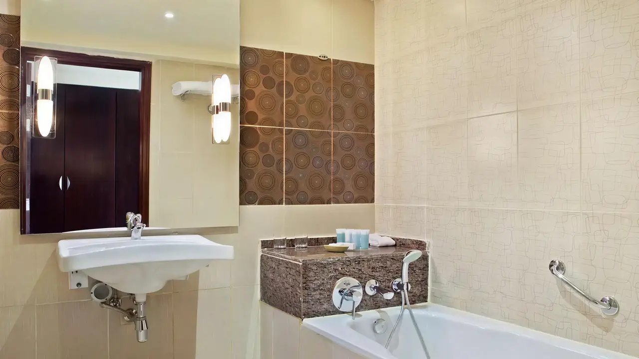Łazienka w Doubletree by Hilton Sharks Bay z wanną i umywalką