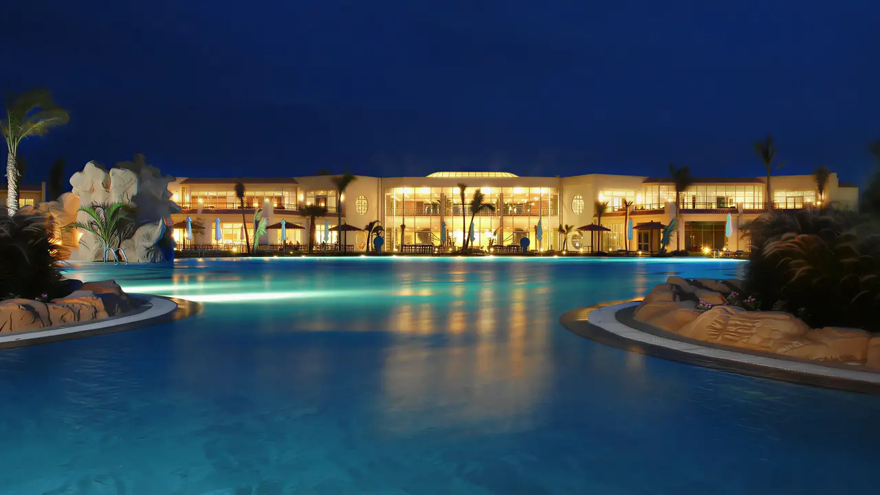 Oświetlony basen w Doubletree by Hilton Sharks Bay po zmroku