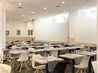 Restauracja w hotelu Dwo Sirius (Santa Susanna) z ustawionymi stolikami