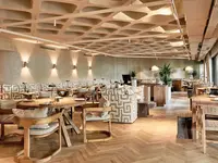 Restauracja w hotelu Eden Mar z drewnianymi stolikami