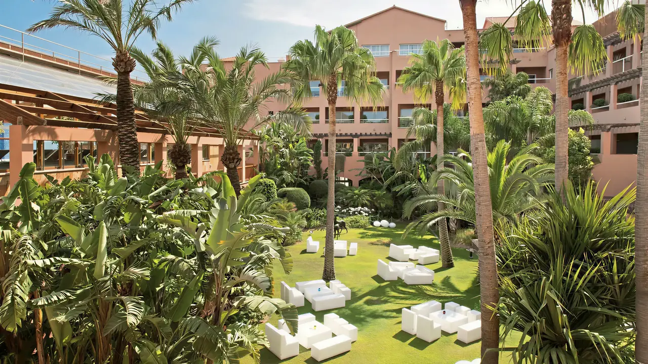 Ogród z białymi meblami w Elba Estepona Gran Hotel Thalasso & Spa