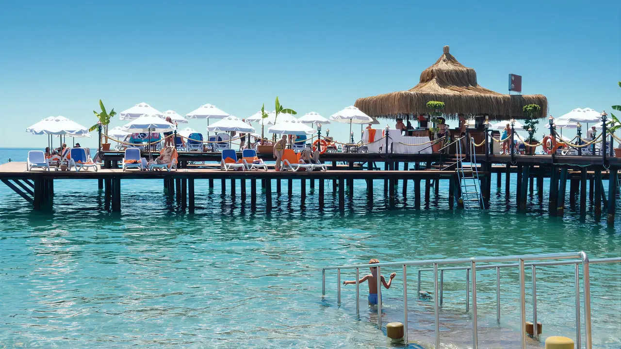 Pomost z leżakami i parasolami w Emelda Sun Club