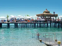 Pomost z leżakami i parasolami w Emelda Sun Club