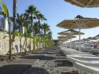 Leżaki i parasole na plaży w Emelda Sun Club