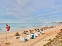 Plaża z leżakami i parasolami w Epic Sana