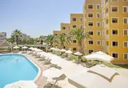Basen z leżakami i parasolami w Esra & Family Suite