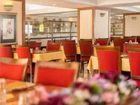 Restauracja z czerwonymi krzesłami w Esra & Family Suite