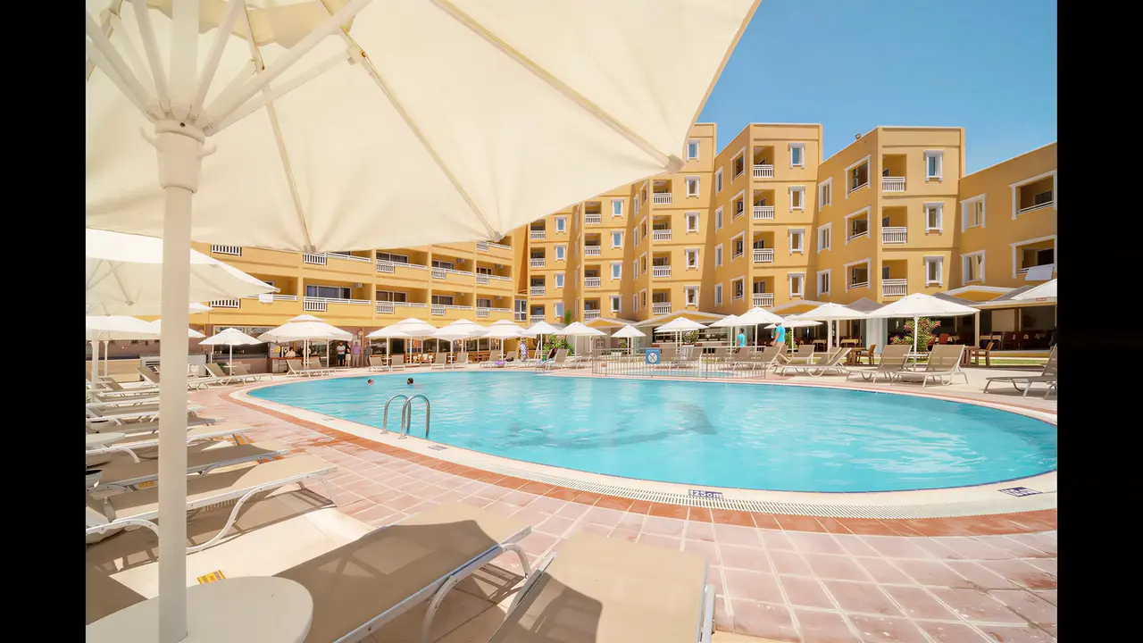 Basen z leżakami i parasolami w Esra & Family Suite