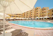 Basen z leżakami i parasolami w Esra & Family Suite