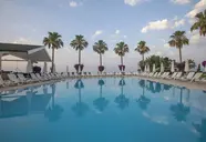 Basen z leżakami i palmami w Falcon