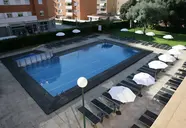 Basen z leżakami i parasolami w Fenals Garden