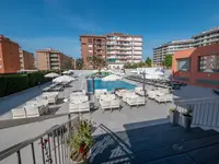 Basen z leżakami i parasolami w Fenals Garden