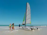Katamaran i osoby na plaży w Fiesta Beach
