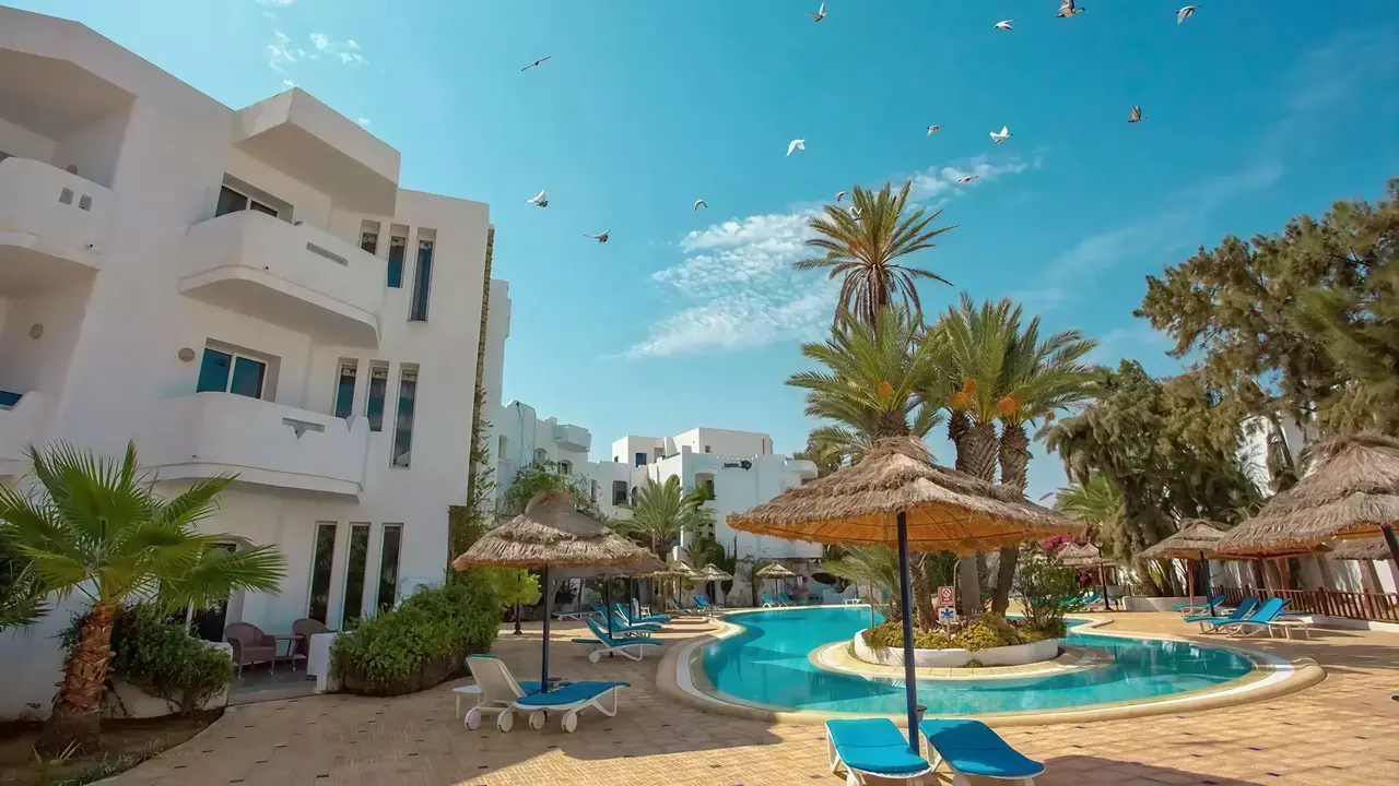 Basen z leżakami i parasolami w Fiesta Beach