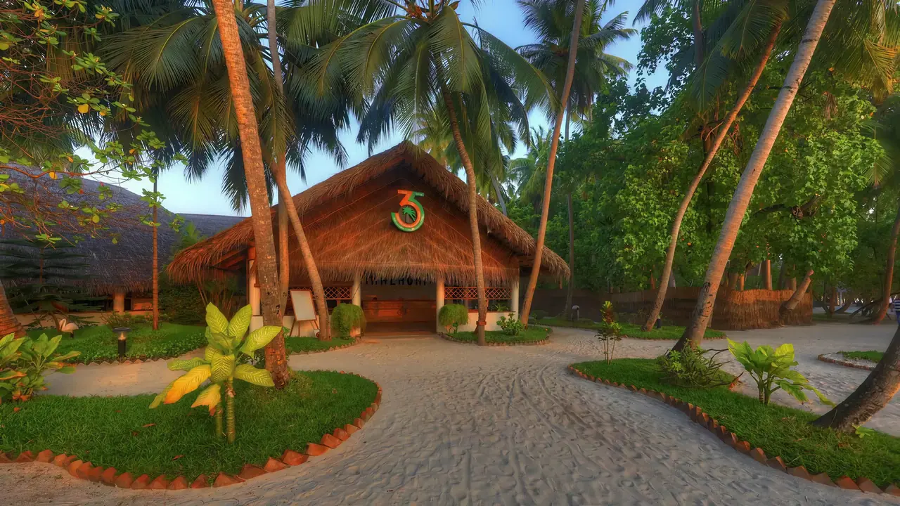 Budynek Fihalhohi Island Resort otoczony palmami i zielenią