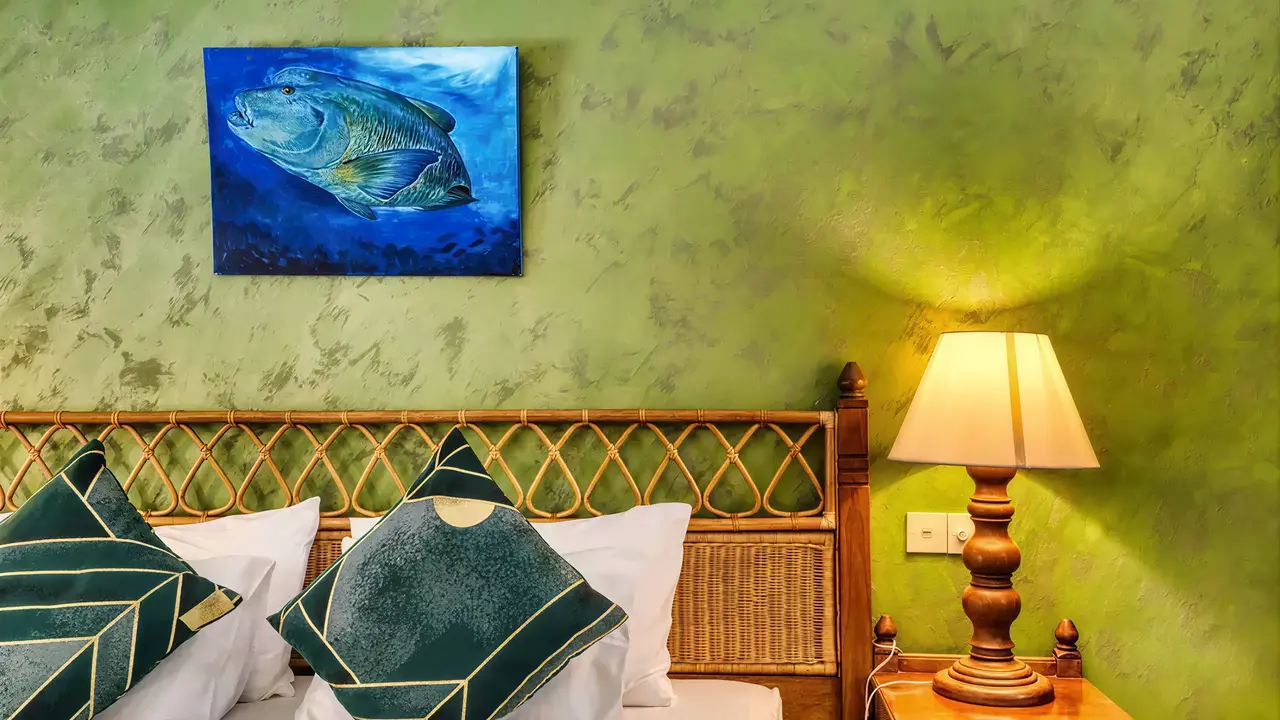 Sypialnia w Fihalhohi Island Resort z zieloną ścianą