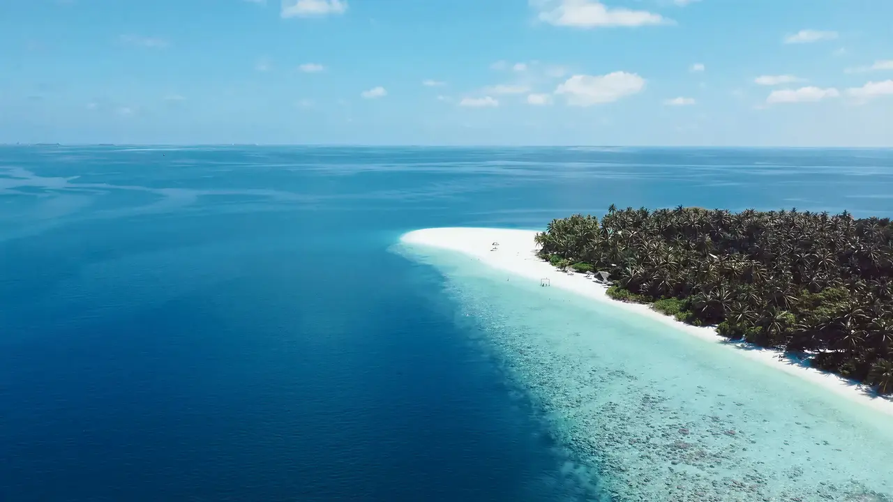 Biała plaża i turkusowe morze w Fihalhohi Island Resort