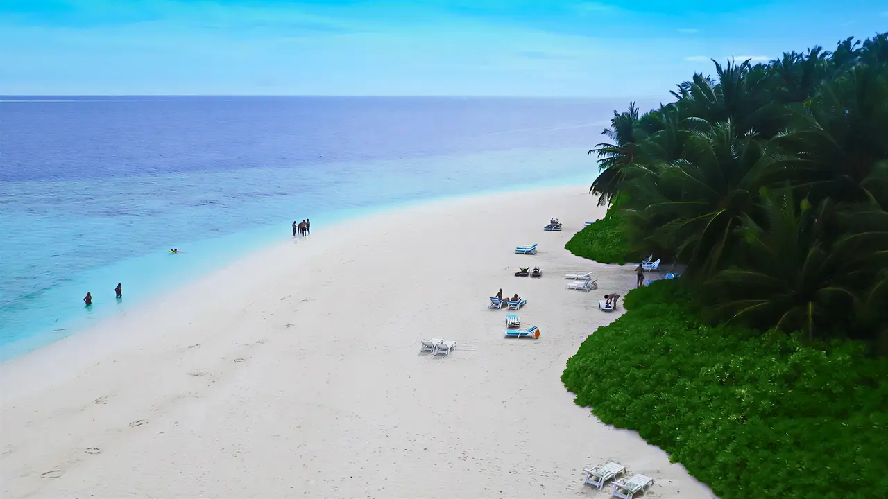 Piaszczysta plaża z leżakami w Fihalhohi Island Resort
