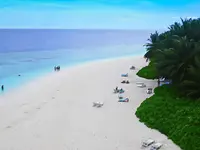 Piaszczysta plaża z leżakami w Fihalhohi Island Resort