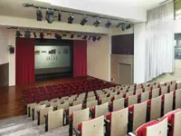 Sala kinowa w Flamingo Grand Hotel & Spa z czerwonymi fotelami