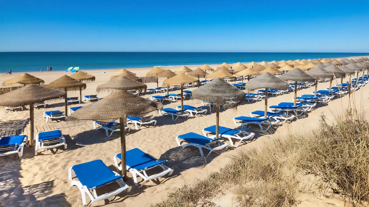 Plaża z leżakami i parasolami w Fuerte el Rompido Spa