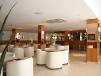 Wnętrze lobby w Garbi Park z białymi fotelami