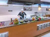 Kucharz przy bufecie z jedzeniem w GHT Costa Brava