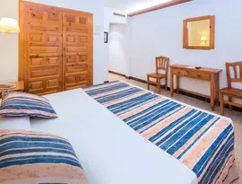 Pokój z łóżkiem i meblami w GHT Neptuno (Tossa de Mar)