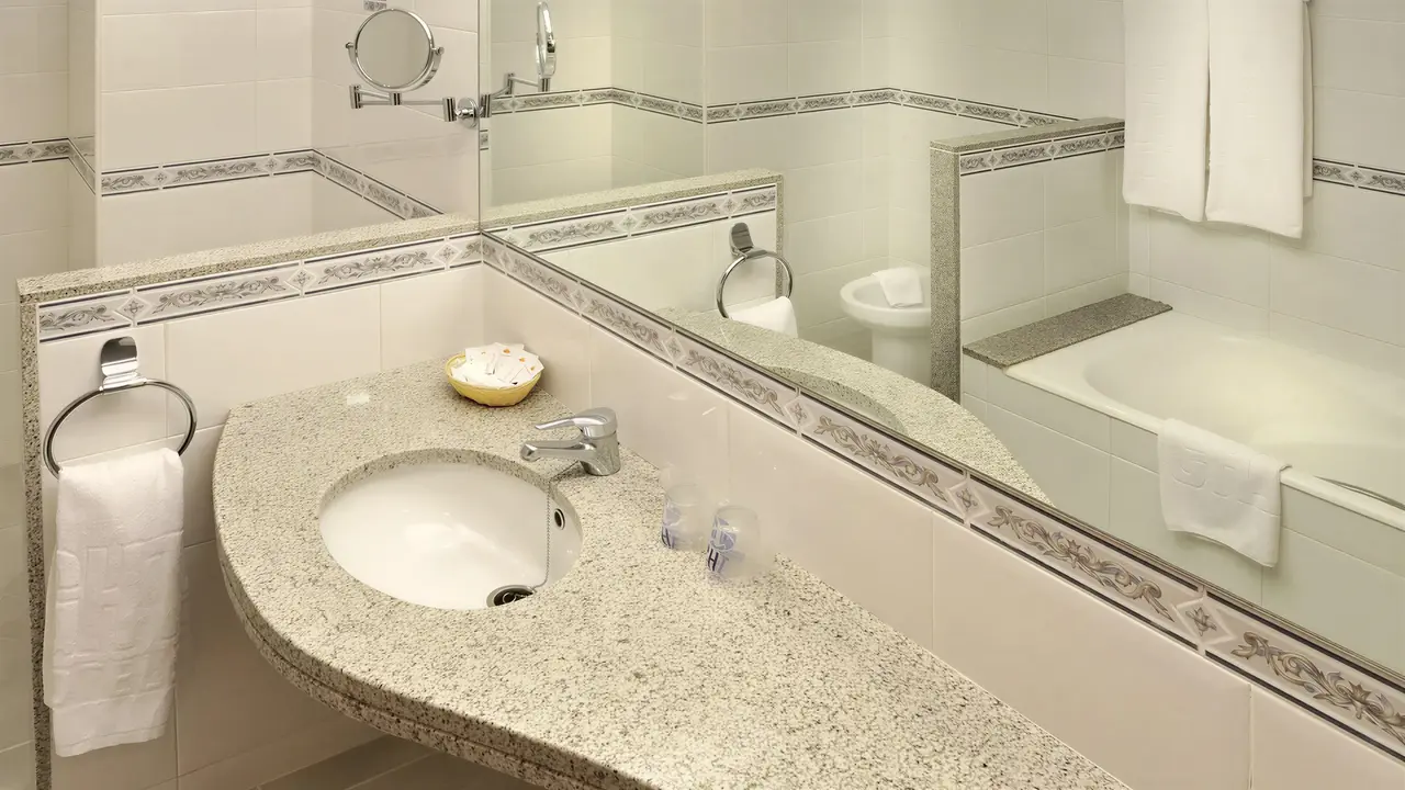 Łazienka w hotelu GHT Oasis Park z umywalką i wanną