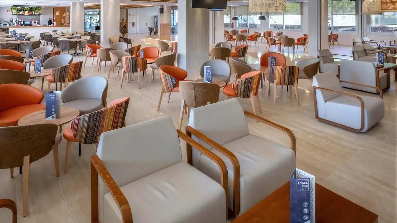 Wnętrze eleganckiego lobby w GHT Oasis Tossa z wygodnymi fotelami